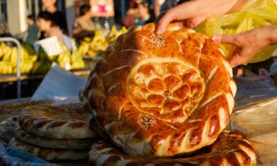 a person holding a piece of bread on top of a table