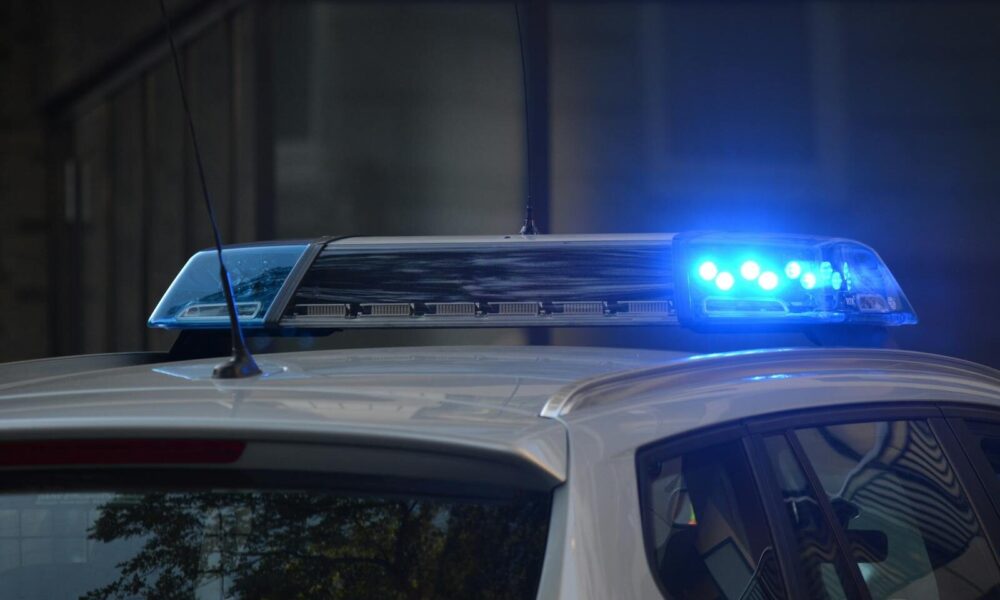 Close-up of a police car's flashing blue lights in an urban environment.