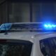 Close-up of a police car's flashing blue lights in an urban environment.