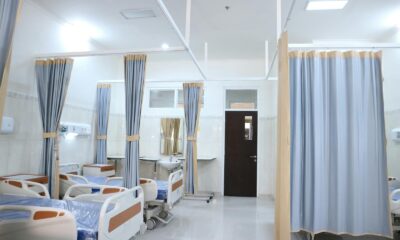 Clean and modern hospital ward with beds and privacy curtains in Surabaya, Indonesia.