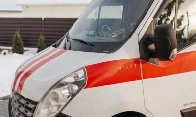 Close-up of a red and white ambulance vehicle parked outdoors during the day.