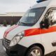 Close-up of a red and white ambulance vehicle parked outdoors during the day.