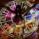 Silhouette of person extending arms against zodiac symbols and cosmic background, esoteric theme.