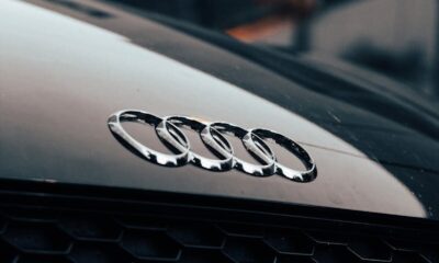 Detailed close-up of a black luxury car's iconic logo and sleek design.