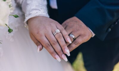 Close-up image of a couple's hands showing off diamond wedding rings, symbolizing love and marriage.