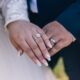 Close-up image of a couple's hands showing off diamond wedding rings, symbolizing love and marriage.