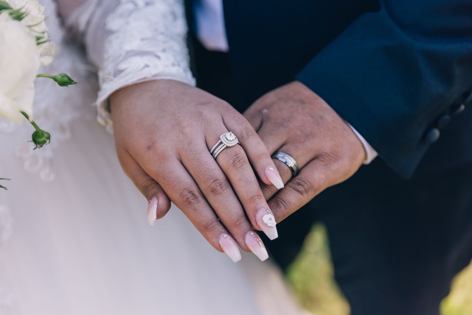 Close-up image of a couple's hands showing off diamond wedding rings, symbolizing love and marriage.