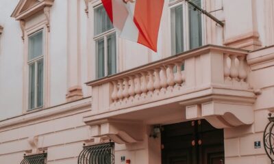 Classic architecture of an Austrian building with a prominent national flag, perfect for urban photography.