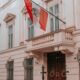 Classic architecture of an Austrian building with a prominent national flag, perfect for urban photography.