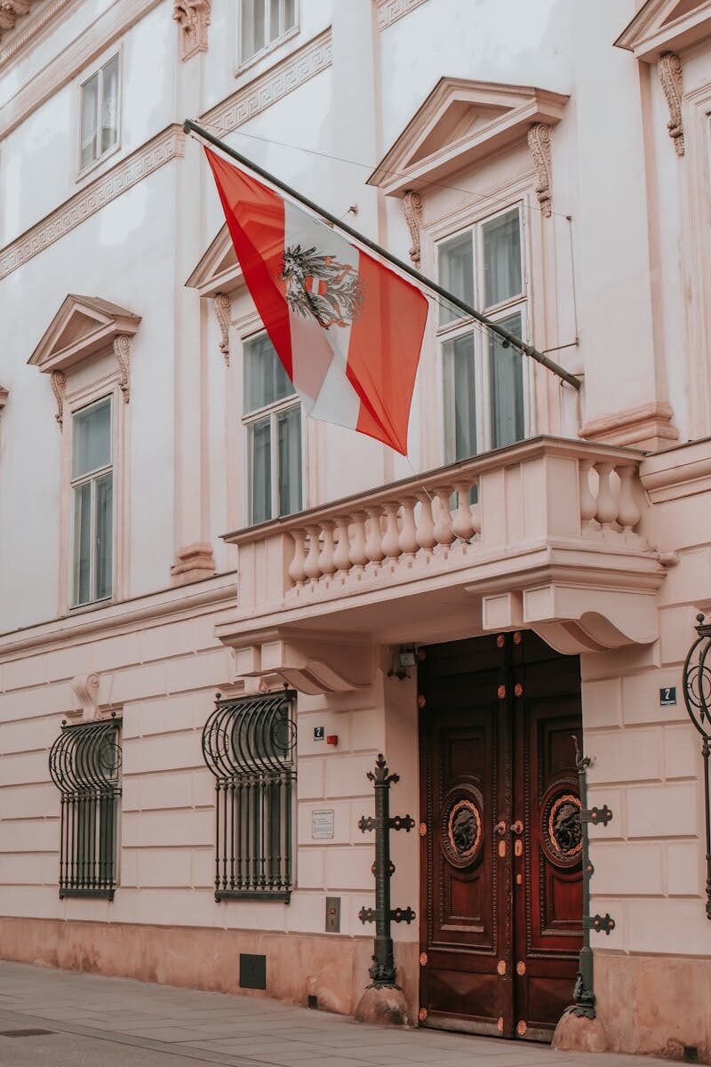 Classic architecture of an Austrian building with a prominent national flag, perfect for urban photography.