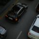 Aerial shot showing multiple cars driving on a city road during the evening, illustrating urban traffic.