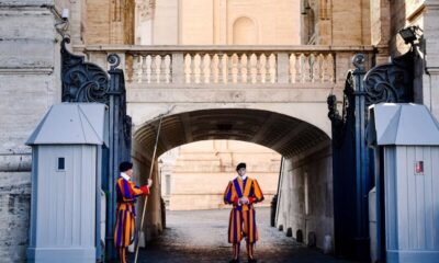Vatican Swiss Guards stand at the entrance, showcasing traditional uniforms in Vatican City.
