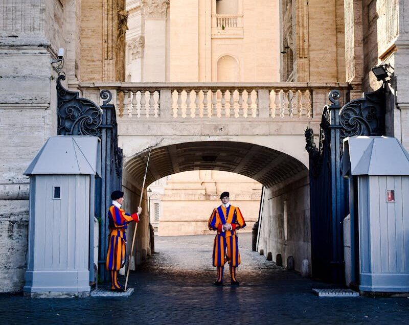 Vatican Swiss Guards stand at the entrance, showcasing traditional uniforms in Vatican City.