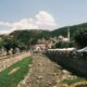 Panoramic view of Prizren's charming riverside cafes and historic architecture on a sunny day.