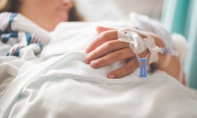 Focused shot of a patient's hand with IV in a hospital setting.