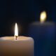Close-up of a burning candle with a soft glow, creating a tranquil atmosphere.