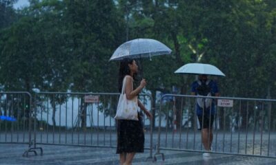 A woman walking with an umbrella during a rainy day, capturing mood and motion.