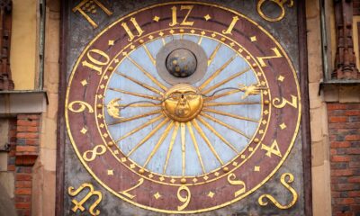 Close-up of a historic astronomical clock on a building facade in Poland.