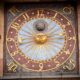 Close-up of a historic astronomical clock on a building facade in Poland.