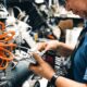 Experienced male technician working on complex machinery in workshop.