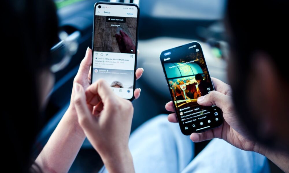 A couple engaging with social media on smartphones indoors, illustrating modern digital connectivity.