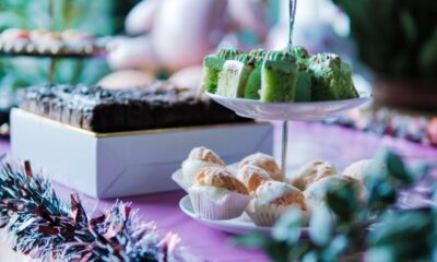 Vibrant party table setup with colorful cakes, pastries, and decorations in a festive setting.