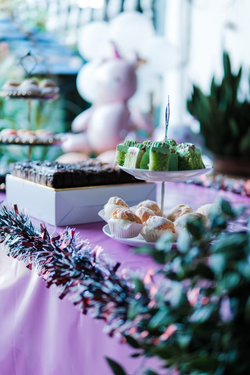 Vibrant party table setup with colorful cakes, pastries, and decorations in a festive setting.
