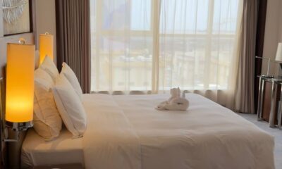 Elegant hotel room with modern decor, large bed, and sunlit window view.