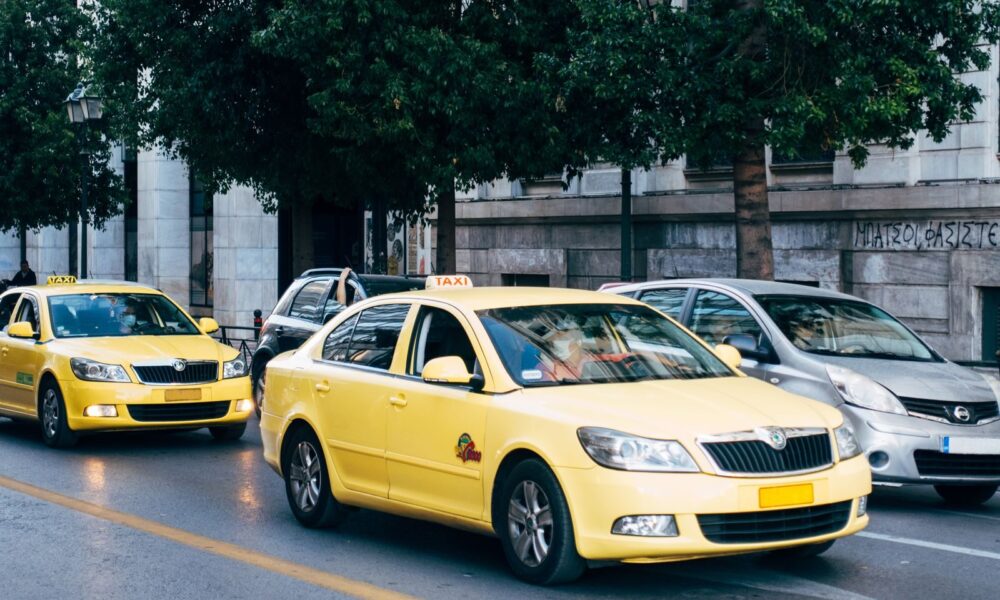 Yellow taxis lining the street in Athens, Greece, showcasing city's bustling transportation.