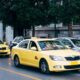 Yellow taxis lining the street in Athens, Greece, showcasing city's bustling transportation.