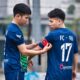 Two soccer players getting ready for a match on a field in Hanoi, Vietnam.