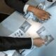Detectives analyzing black and white photos and fingerprints. Investigation process depicted in detailed top view.