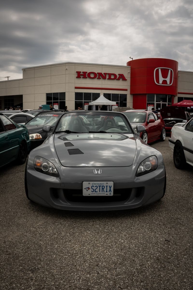 Honda dealership showcasing a sleek parked car on a cloudy day.