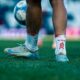 Close-up shot of a soccer player on the field with a focus on the feet and ball.
