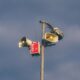 A warning system with loudspeakers on a pole against a cloudy sky, signaling emergency alerts.