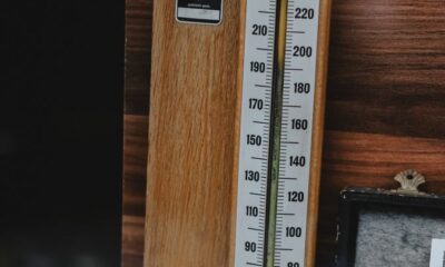 An antique wooden barometer with a classic design, set against a wooden backdrop.