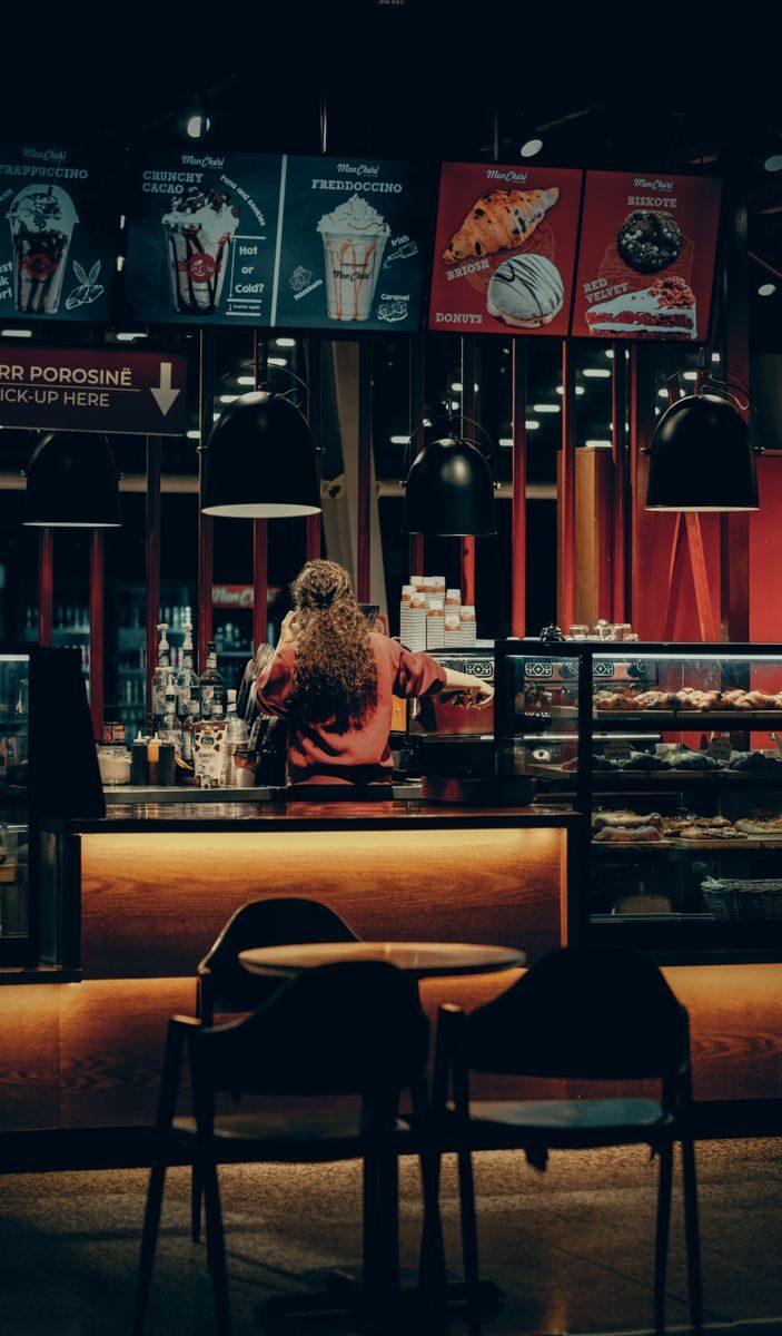 Warmly lit café with a barista working behind the counter, creating an inviting atmosphere.