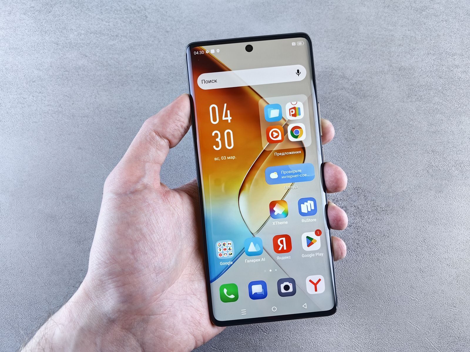 Close-up of a hand holding a smartphone displaying apps on the screen against a textured background.