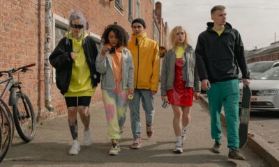 A group of stylish young adults walking together on a city street, showcasing modern fashion.