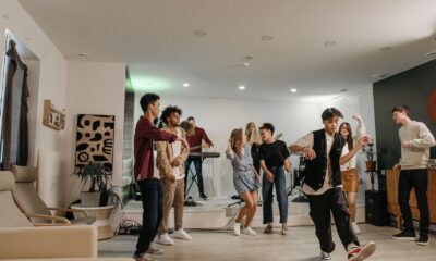 A group of friends enjoying a vibrant indoor party with music and dancing.