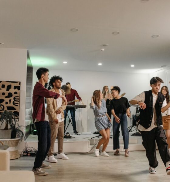 A group of friends enjoying a vibrant indoor party with music and dancing.