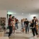 A group of friends enjoying a vibrant indoor party with music and dancing.