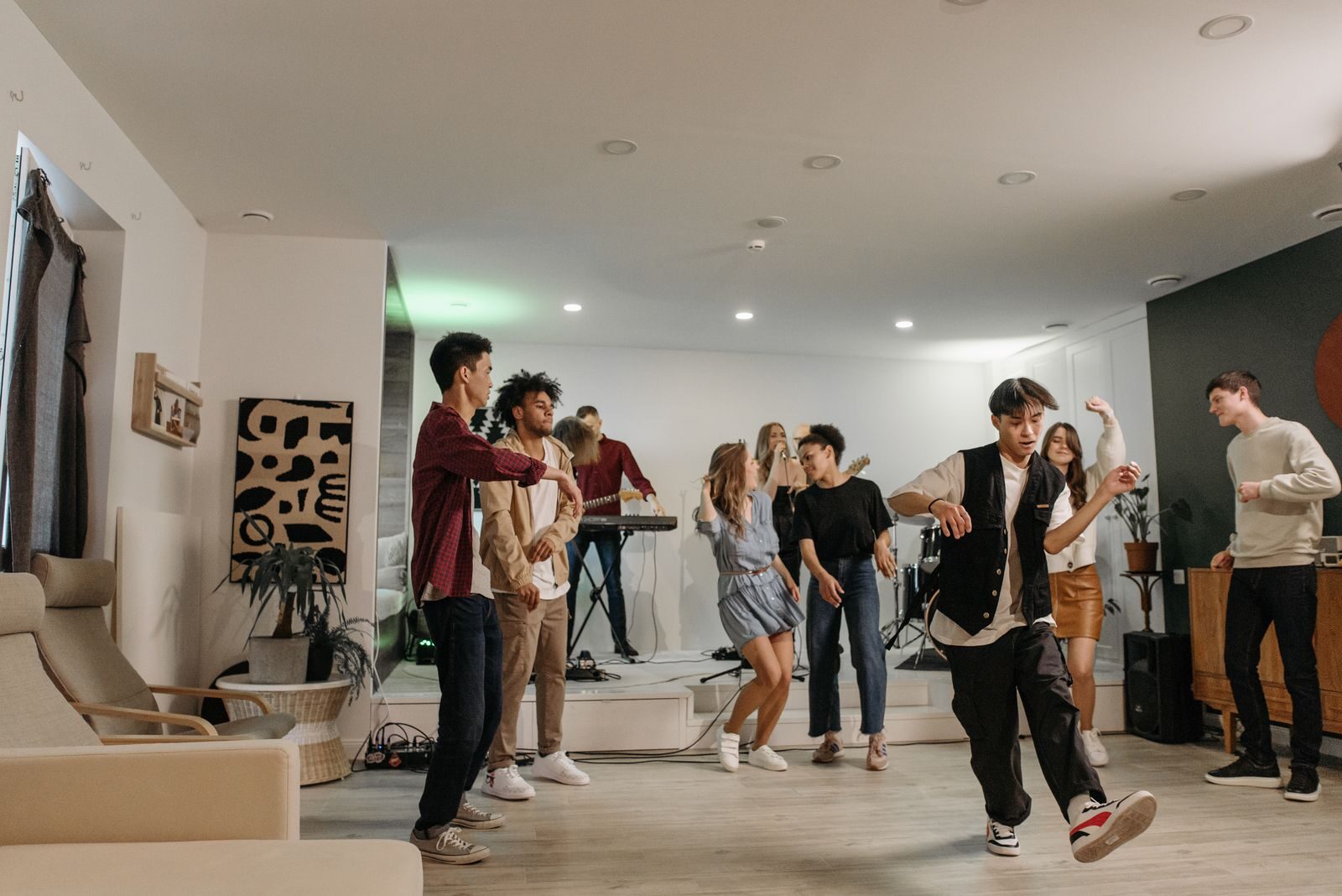 A group of friends enjoying a vibrant indoor party with music and dancing.