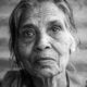 Intimate black and white portrait of an elderly South Asian woman in Varanasi, showcasing wisdom and experience.