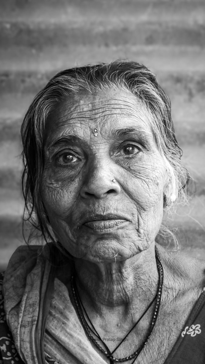 Intimate black and white portrait of an elderly South Asian woman in Varanasi, showcasing wisdom and experience.