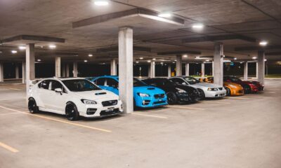 Bright new expensive automobiles placed on parking lot under concrete roof with bright lights