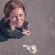 Aerial view of a frustrated woman on pavement next to spilled ice cream.