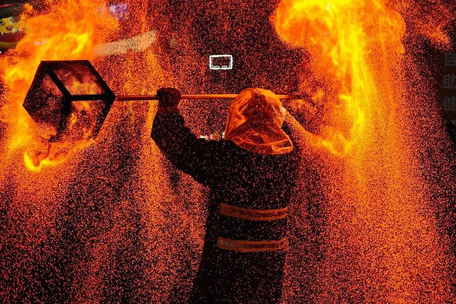 Stunning fire performer with flames and sparks in a nighttime show.