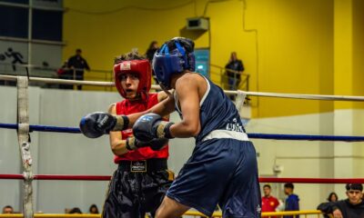 Two athletes engaged in a competitive boxing match, showcasing skill and determination.