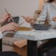 Two women sharing a healthy meal indoors, emphasizing friendship and togetherness.